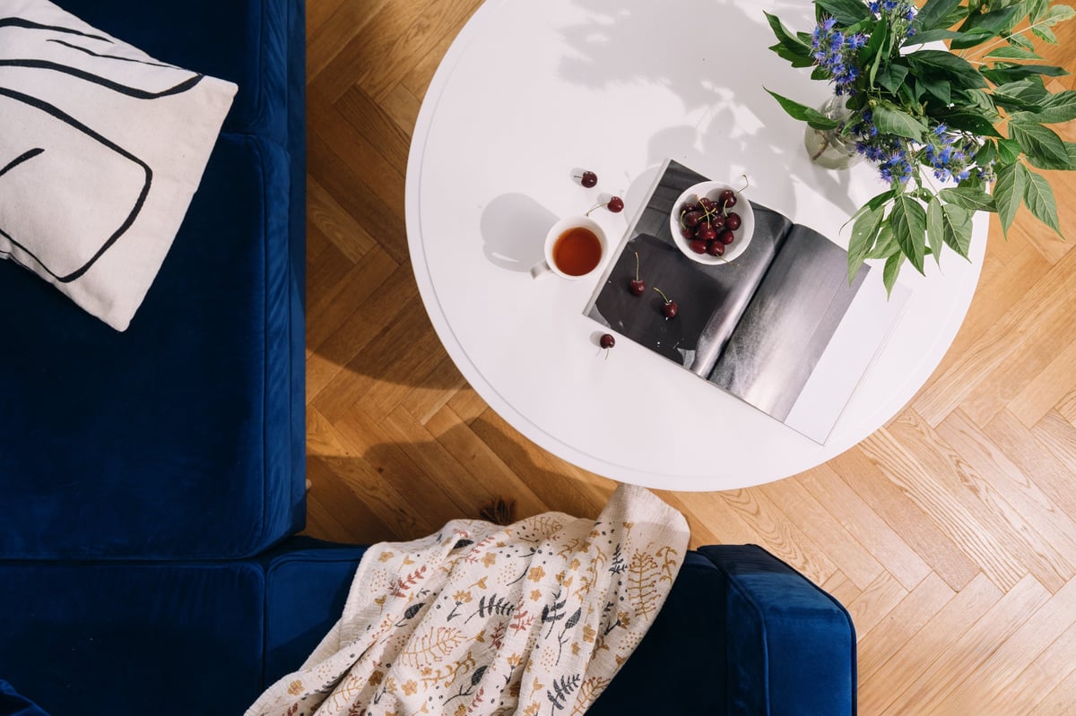 A peaceful RiverTown living room with a coffee and journal on a white coffee table